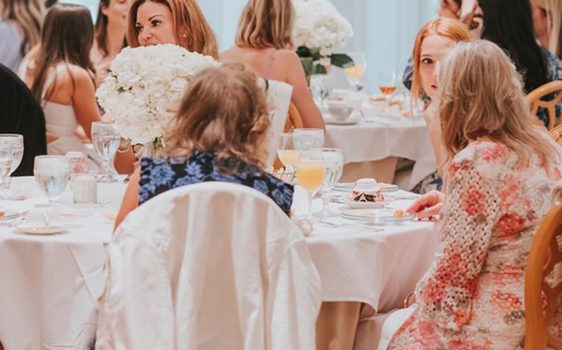 Women leaders gathered around a table with hydrangeas and breakfast