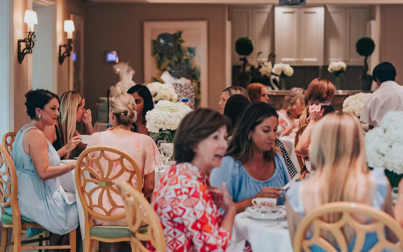 Round tables set with white hydrangea centerpieces for a women's gathering